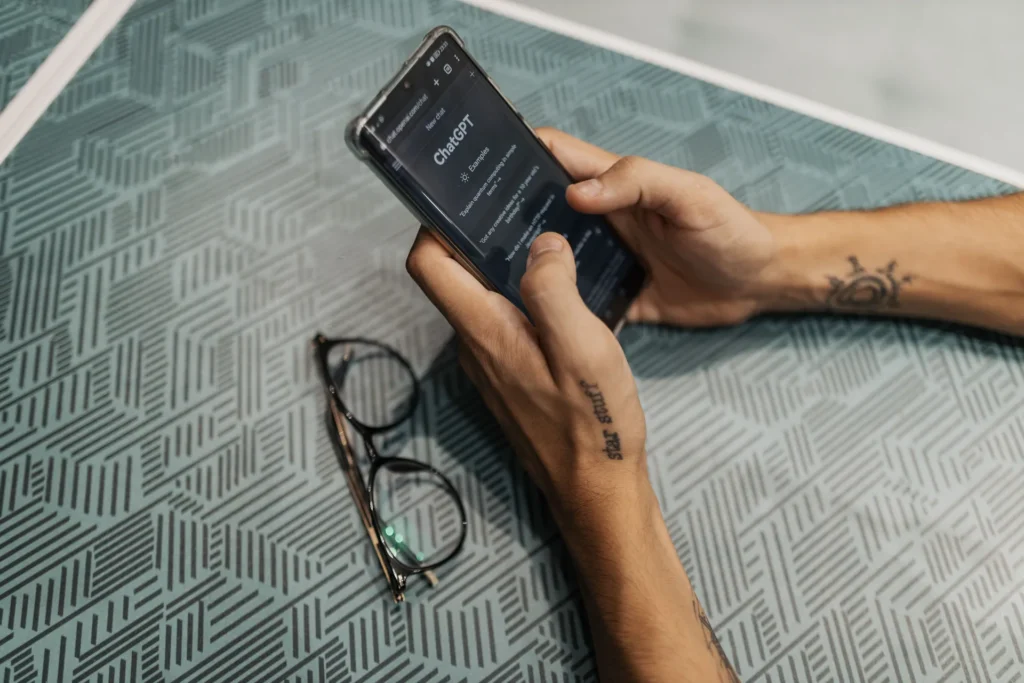 	Pessoa fazendo uma pergunta de busca em um assistente de IA pelo celular