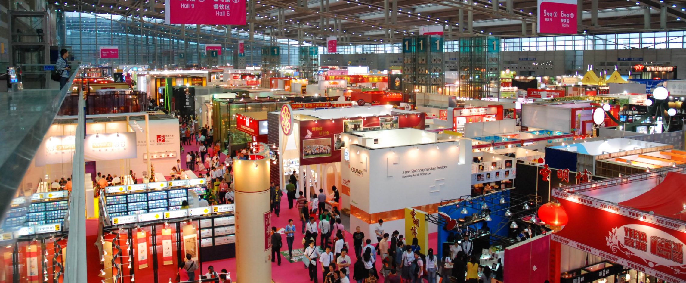 Corredor de pavilhão lotado durante uma das grandes feiras na China, com visitantes circulando entre estandes